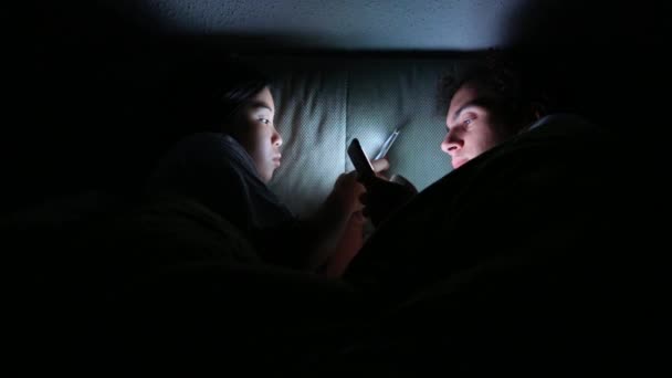 Para Przeglądająca Swoje Smartfony Nocy Łóżku Patrząc Sobie Oczy — Wideo stockowe