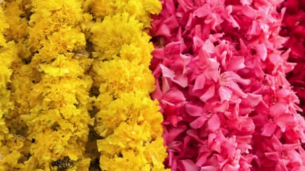 Een Array Van Gele Roze Bloemenslingers Opknoping Van Een Kraam — Stockvideo