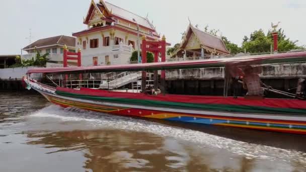 在曼谷一座寺庙前的一条水渠上行驶的长船 — 图库视频影像