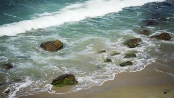 浪花飞溅在岩石和海滩上 阳光灿烂的日子在美丽的海滩上 — 图库视频影像