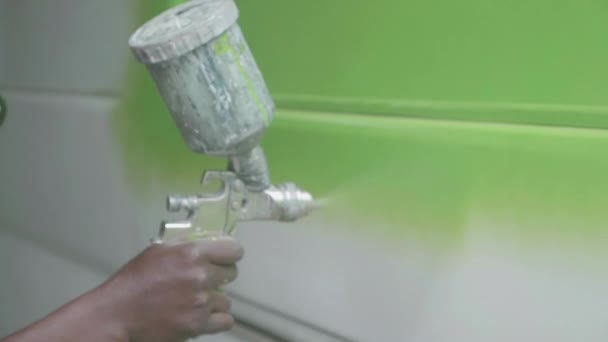 작업실에서 남자가 자동차에 페인트를 뿌리는 — 비디오