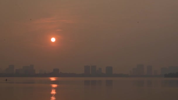 在河内的西湖边 夕阳西下 天空橙色 轮廓分明的城市远在天边 — 图库视频影像
