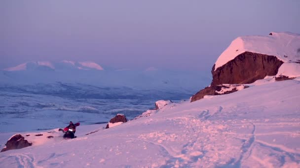 Snowmobile Rider Carrying Snowboard Beautiful Midnight Sun Light Filmed Riksgrnsen — Stock Video