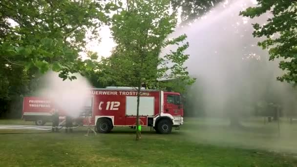 Niemiecki Firetruck Spryskiwanie Wody Dla Dzieci Drzew Upalny Letni Dzień — Wideo stockowe