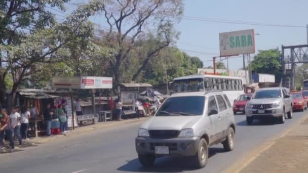 車や人で賑わう通り沿いに立つ — ストック動画