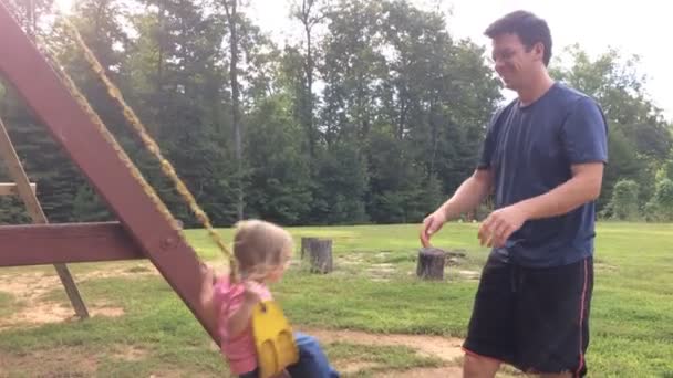 爸爸推着小女儿在后院荡秋千 — 图库视频影像