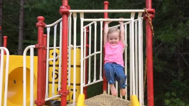Little girl playing on playground equipment outdoors