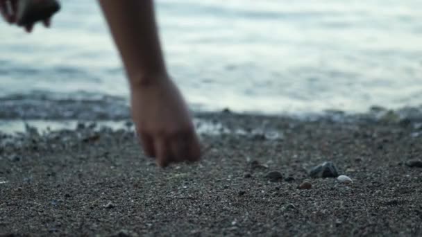 Chica Recoge Guijarros Una Playa Frente Mar Atardecer — Vídeos de Stock