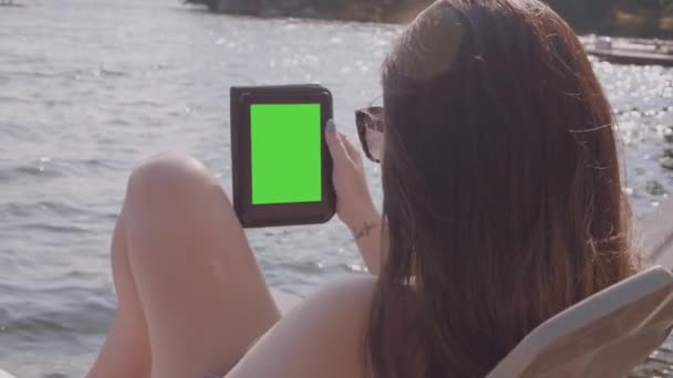 Powolny Ruch Wokół Młodej Kobiety Kostiumie Kąpielowym Czytającej Zieloną Tabliczkę — Wideo stockowe