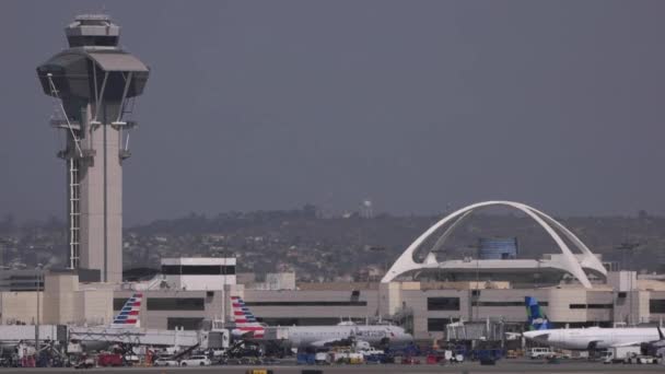 英国航空公司的一架A380空中客车在洛杉矶国际机场的标志性拱门和控制塔后面的24R跑道着陆 — 图库视频影像