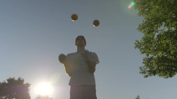 Man Juggling Τέσσερις Μεγάλες Μπάλες Στήλες Κατά Διάρκεια Ενός Όμορφου — Αρχείο Βίντεο