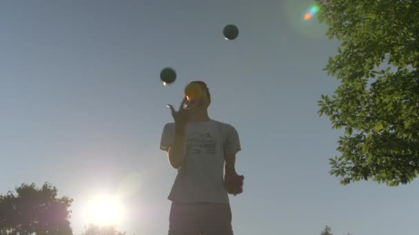 Mann Jongliert Mit Vier Großen Bällen Bei Einem Schönen Sonnenuntergang — Stockvideo