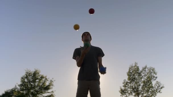 Hombre Haciendo Malabares Con Cuatro Bolas Grandes Coloridas Atardecer Cámara — Vídeos de Stock