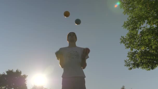 Man Juggling Τέσσερις Μεγάλες Μπάλες Στήλες Κατά Διάρκεια Ενός Όμορφου — Αρχείο Βίντεο