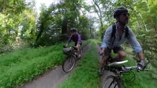 相机盘作为一个成熟的女人骑自行车向后移动 相机显示一对成熟的夫妇骑自行车在一起 — 图库视频影像