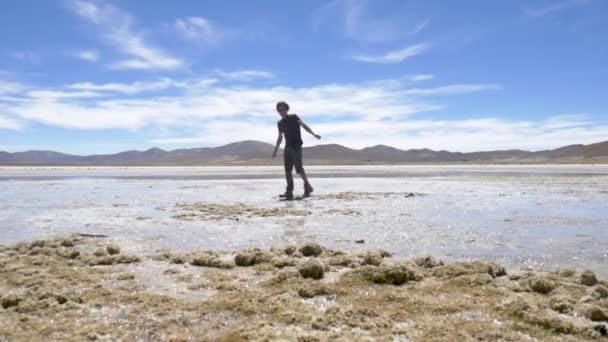 チリのサンペドロ アタカマの北にあるボリビアの砂漠の湖を歩く冒険者 — ストック動画