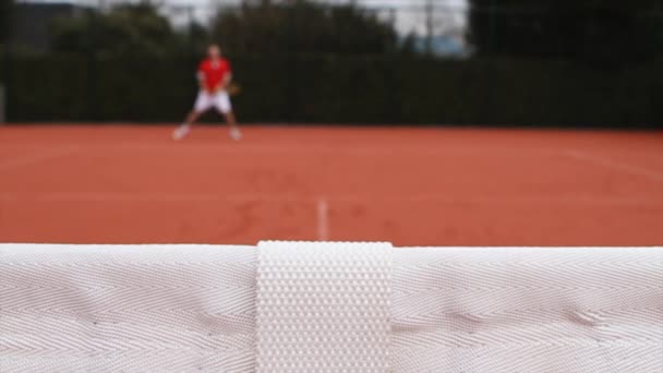 男子テニスのアブストラクトショット ネットに集中しろ プレーヤーアウトフォーカス — ストック動画