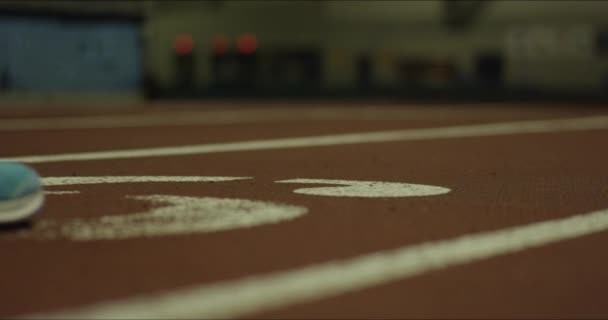 一个沉思中的女运动员在跑道上走上正轨的电影镜头 — 图库视频影像