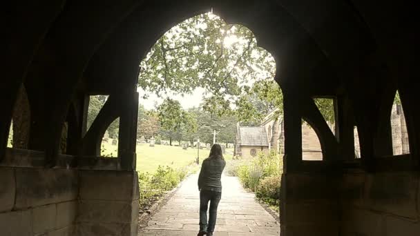 Donna Cammina Attraverso Ingresso Della Chiesa Illuminata Dal Sole — Video Stock