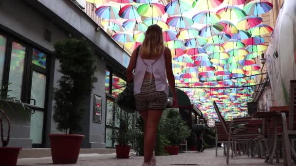 Κορίτσι Που Περνά Από Φωτεινό Πολύχρωμο Umbrella Street — Αρχείο Βίντεο