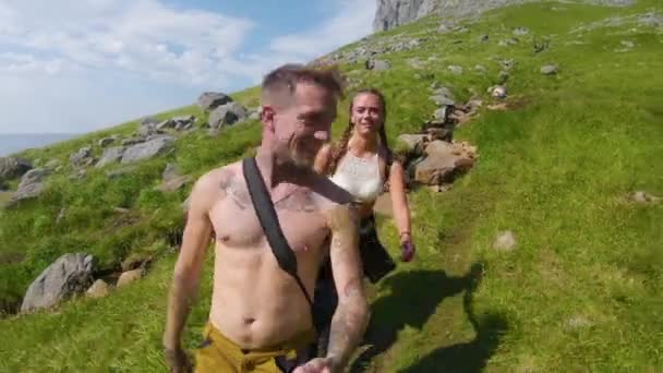 Ein Junges Paar Das Auf Einem Felsigen Grünen Hang Wandert — Stockvideo