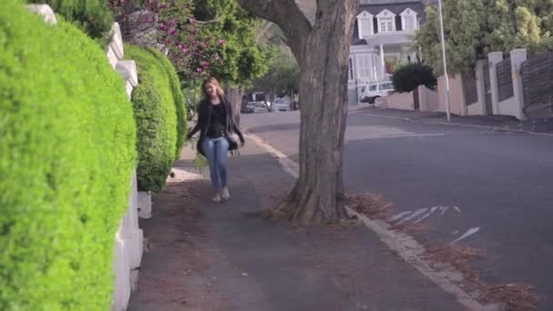 Kobieta Idąca Chodnikiem Obok Żywopłotu — Wideo stockowe