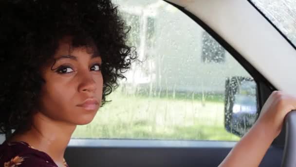 シネマグラフ 雨の日に車の後ろに座っている魅力的なアフリカ系アメリカ人女性 シームレスな動きフォトループ — ストック動画