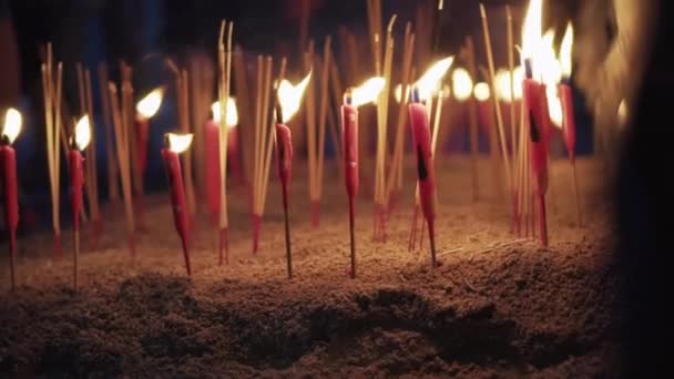 Schwenkender Schuss Brennender Roter Kerzen Und Räucherstäbchen Auf Dem Boden — Stockvideo