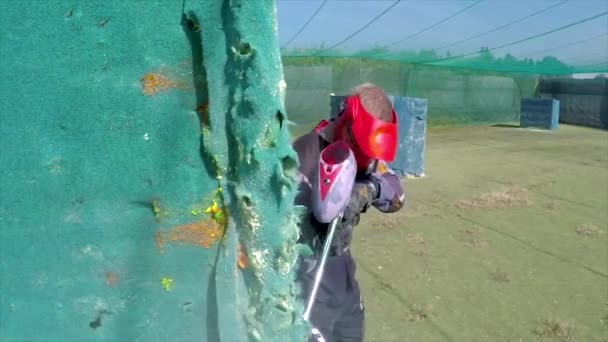 Paintballer Escondido Detrás Pared Mientras Las Bolas Explotan — Vídeos de Stock