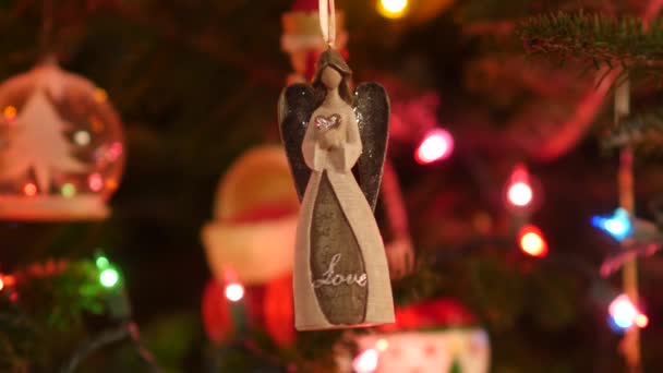 天使圣诞装饰品的静态镜头挂在圣诞树上 圣诞树上的装饰品将焦点放在装饰品后面 使人们重新聚焦 — 图库视频影像
