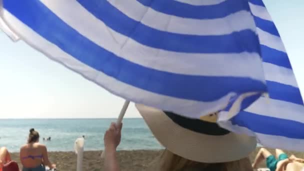 Young Woman Opening Parasol Beach Umbrella White Navy Blue Stripes — Stock Video