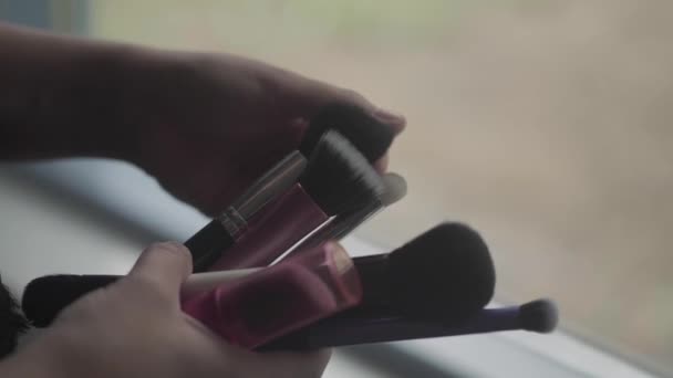 Mujer Moviéndose Través Una Selección Pinceles Maquillaje Lado Una Ventana — Vídeo de stock
