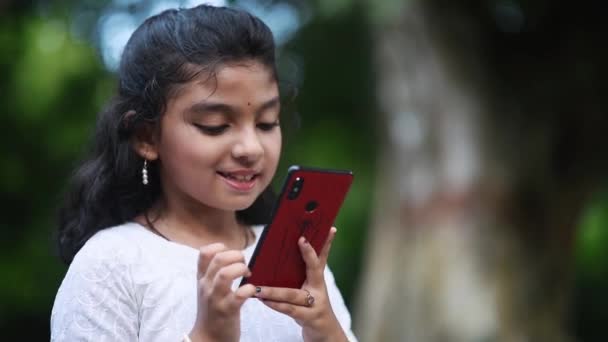 Uma Menina Asiática Alegre Está Usando Seu Telefone Celular Para — Vídeo de Stock
