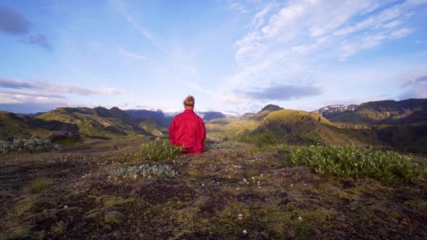 ある男がソルスモーク アイスランドの山の上で瞑想している 壮大なアイスランドの自然 美しい高原の風景 リラックスするための平和的 インスピレーションと動機付けの場所 — ストック動画