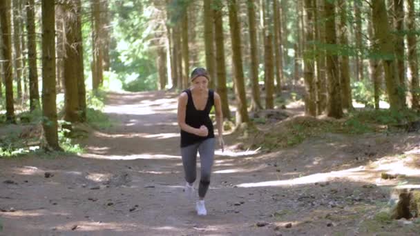 年轻女子健美 开始在公园的小径上奔跑 当她奔向摄像机时 专注而坚定的面部表情 慢动作 — 图库视频影像