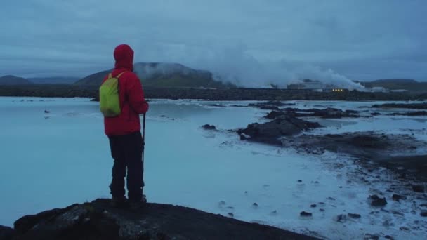 アイスランド 夜の青いラグーン サルツェンギ発電所 青い水の周りを歩く一人 カメラの動き 追跡に続くカメラ — ストック動画