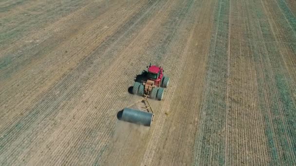 Aerial Video Red Tractor Towing Stone Roller Bare Paddock — Stock Video