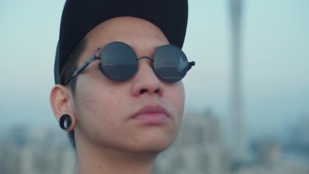 スローモーションクローズアップ若いアジアの写真家の撮影スカイラインは屋上から早朝に彼のサングラスに反映 — ストック動画