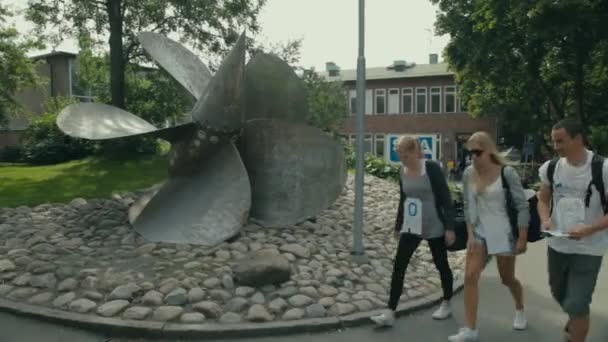 Students walk past a large propeller used as a decoration on the Chalmers University campus.