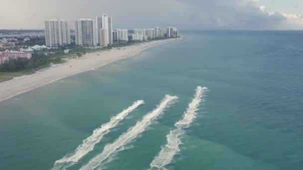 フロリダ州シンガー島のビーチで海岸線を駆け上がる複数のジェットスキーの空中ドローン映像 — ストック動画