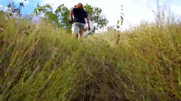 在朋友穿过田野的草丛后面开枪射击 — 图库视频影像
