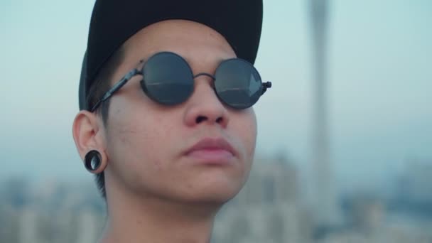 아시아인 사진사를 클로즈업 사진은 옥상에서 자신의 선글라스에 반사된 스카이라인을 — 비디오