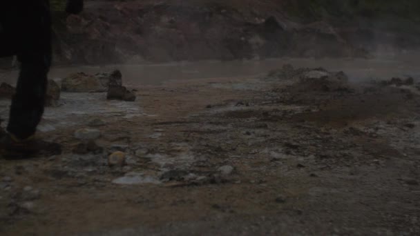 アイスランドの風景地熱温泉蒸気煙フレームの上を歩く人の足の中間部 — ストック動画