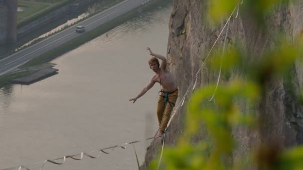 日落时运动员在高高的悬崖峭壁上的高线上 — 图库视频影像
