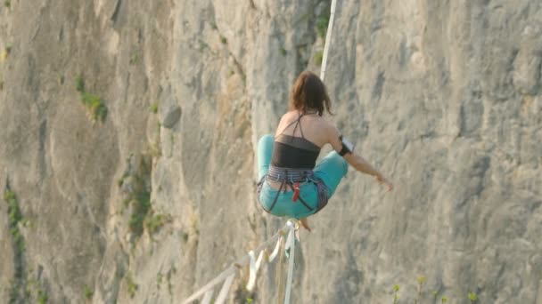 Atlet Menyeimbangkan Pada Garis Tinggi Slack Line Atas Tebing Pegunungan — Stok Video