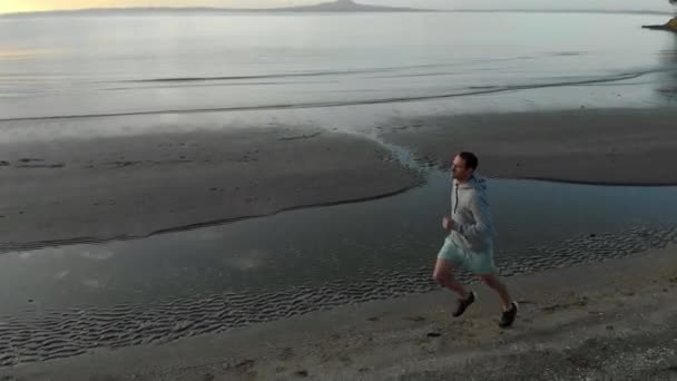 Aerial Tracking Shot Fit Young Caucasian Man Running Beach Auckland — Stock Video