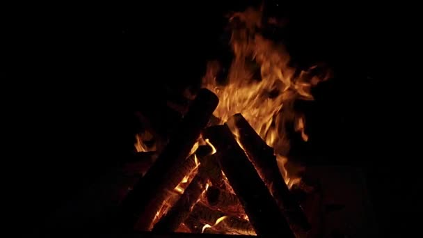 Střední záběr táboráku s plameny a hořícími poleny ve zpomaleném filmu