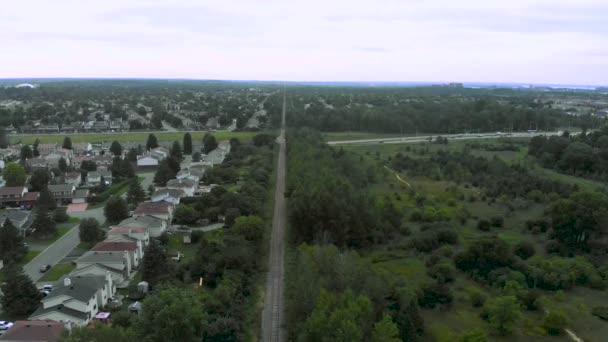 在小分区和森林上空的空中图像 夜间中段的火车轨道 — 图库视频影像