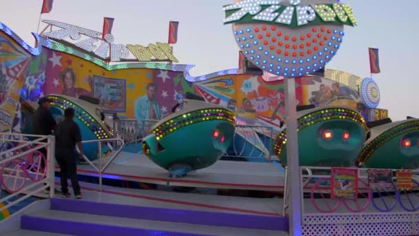 Attendants Watch Spinning Whirling Saucer Thrill Ride Slow Motion Dusk — Stock Video