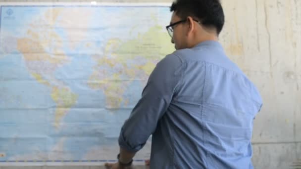 Człowiek Szczęśliwy Turysta Azjatycka Planowanie Podróży Mapa Świata Ścianie — Wideo stockowe